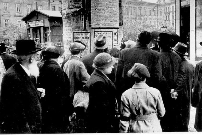 Polish jews and aryans reading a notice about the German attack